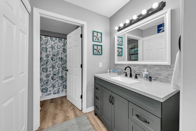 bathroom featuring backsplash, a shower with curtain, vanity, a textured ceiling, and hardwood / wood-style flooring