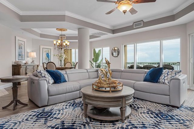 living room featuring a wealth of natural light, ceiling fan with notable chandelier, and ornamental molding