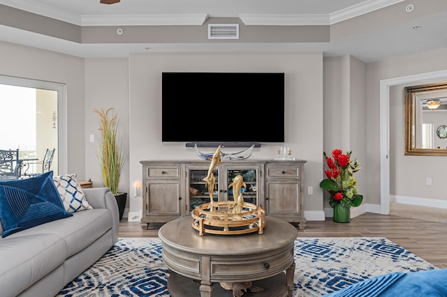 living room with crown molding, ceiling fan, and light wood-type flooring