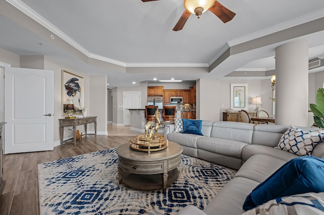 living room featuring a tray ceiling, ceiling fan, and ornamental molding