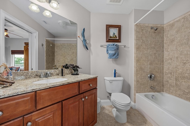 full bathroom with ceiling fan, tile patterned flooring, toilet, vanity, and tiled shower / bath