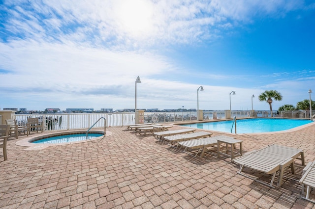 view of swimming pool featuring a community hot tub and a patio area