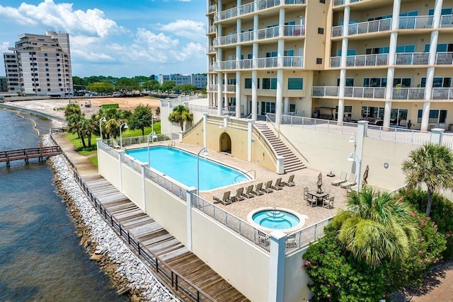 view of swimming pool featuring a patio and a water view