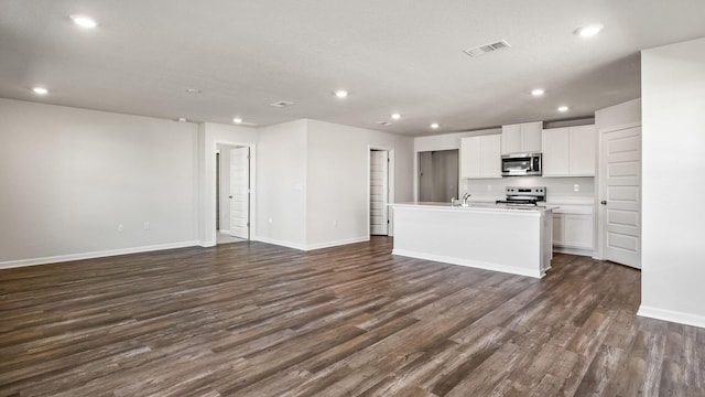 232 Laurel Hill St, Crestview, FL 32539 - kitchen featuring stainless steel appliances, dark hardwood / wood-style floors, a kitchen island with sink, and white cabinets