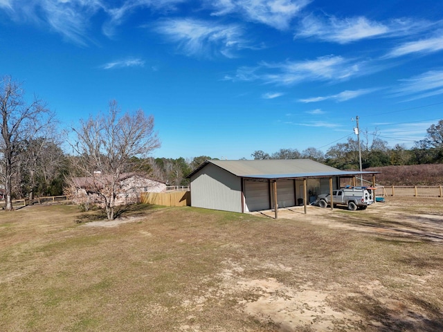 exterior space featuring a lawn, a garage, an outdoor structure, and a carport