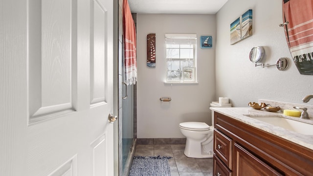 bathroom featuring tile patterned flooring, vanity, toilet, and walk in shower