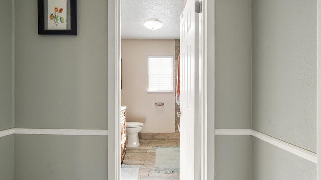 bathroom with vanity, hardwood / wood-style floors, a textured ceiling, and toilet