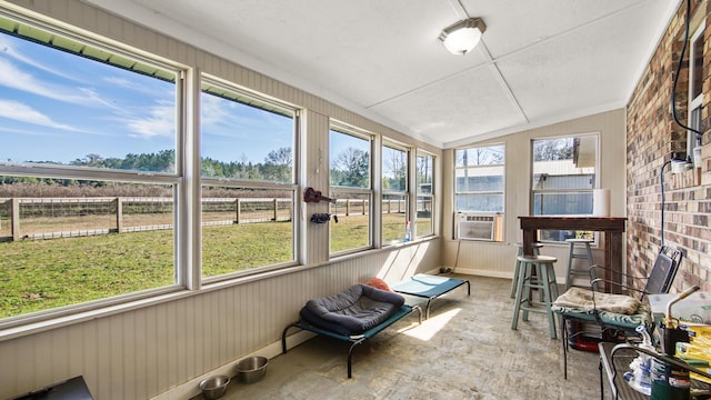 sunroom / solarium with cooling unit, a healthy amount of sunlight, and lofted ceiling