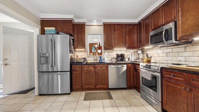 kitchen with sink, stainless steel appliances, decorative backsplash, light tile patterned floors, and ornamental molding