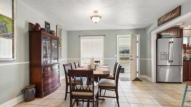 dining room featuring light tile patterned floors and a textured ceiling