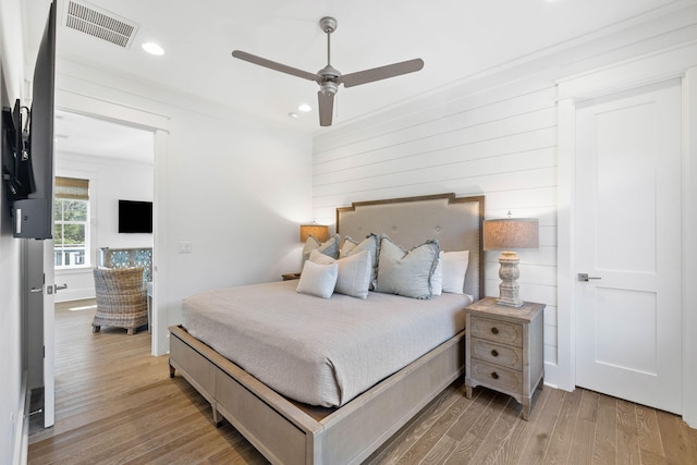 bedroom featuring ceiling fan, light hardwood / wood-style flooring, and ornamental molding