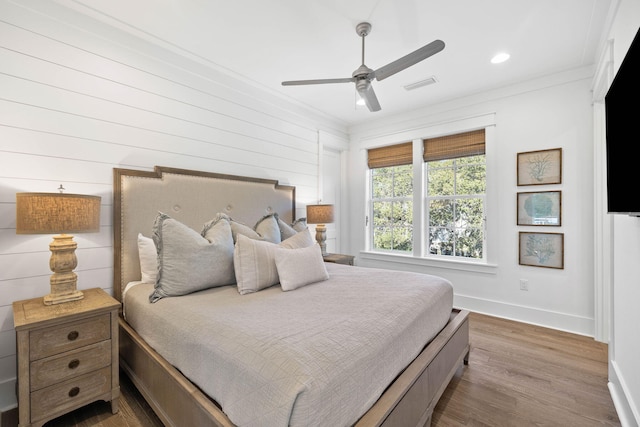 bedroom with hardwood / wood-style floors, ceiling fan, and crown molding