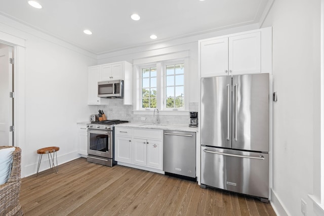 kitchen featuring white cabinets, tasteful backsplash, high quality appliances, and sink