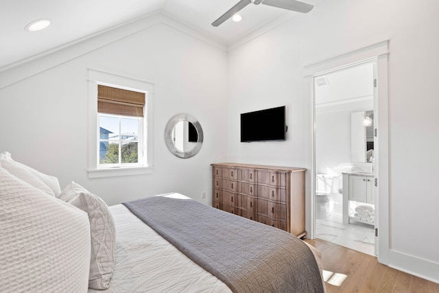 bedroom featuring ceiling fan, lofted ceiling, ensuite bathroom, and light hardwood / wood-style flooring