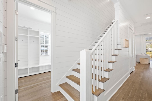 staircase featuring hardwood / wood-style floors and wooden walls