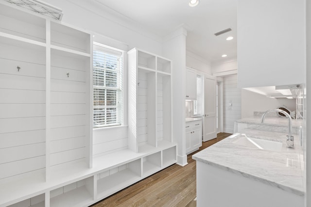 mudroom featuring crown molding, wood-type flooring, and sink