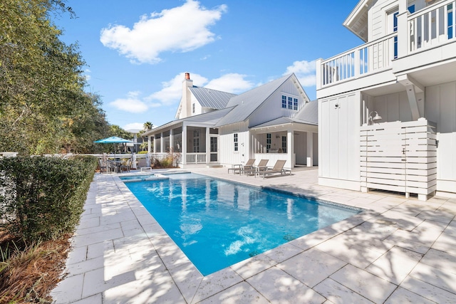 view of pool with a sunroom and a patio