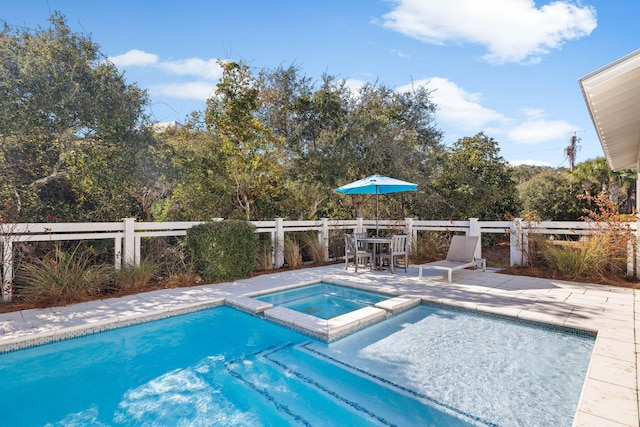 view of pool with a patio area and an in ground hot tub