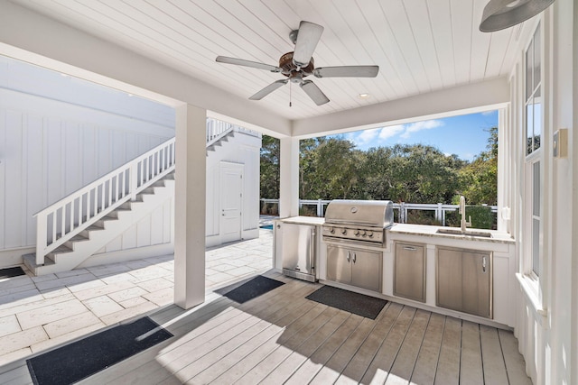 wooden terrace featuring sink, area for grilling, ceiling fan, and exterior kitchen