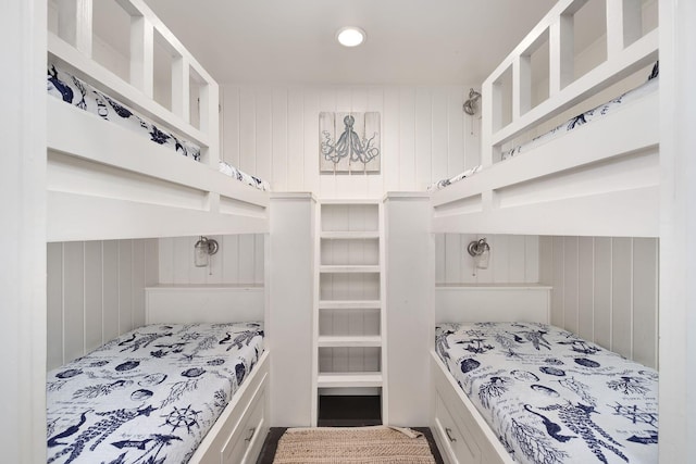 bedroom featuring wood walls