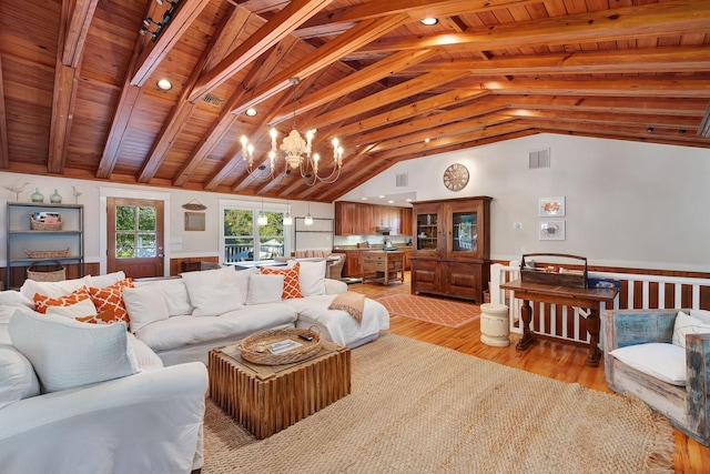 living room with lofted ceiling with beams, wood ceiling, light wood-type flooring, and a notable chandelier