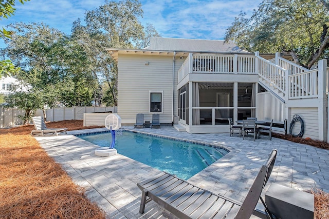 view of swimming pool with a sunroom and a patio