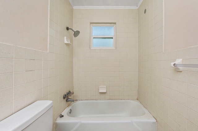 bathroom with crown molding, tiled shower / bath, toilet, and tile walls