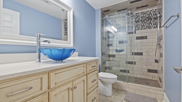 9860 S Thomas Dr Unit 1805, Panama City Beach, FL 32408 - bathroom with vanity, hardwood / wood-style flooring, toilet, and a shower with door