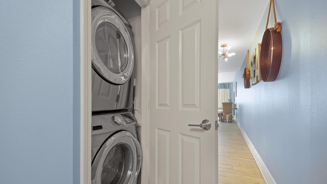9860 S Thomas Dr Unit 1805, Panama City Beach, FL 32408 - clothes washing area featuring light hardwood / wood-style floors, an inviting chandelier, and stacked washer / dryer