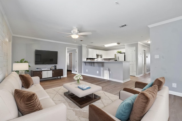 living room featuring light wood-type flooring, crown molding, and ceiling fan