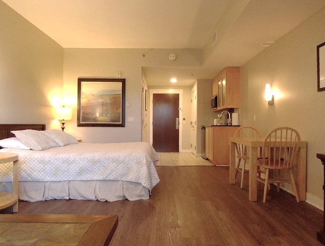 bedroom featuring sink and light wood-type flooring