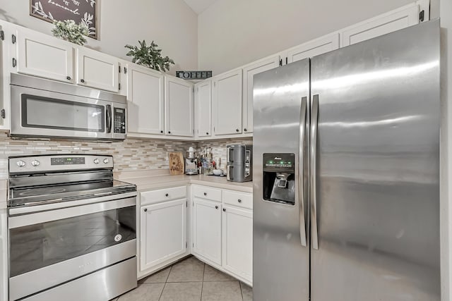 kitchen with light tile patterned floors, stainless steel appliances, and white cabinetry