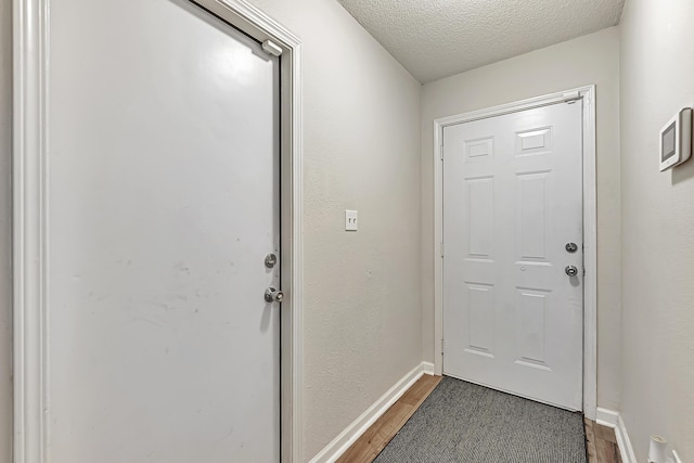 entryway with a textured ceiling and dark wood-type flooring