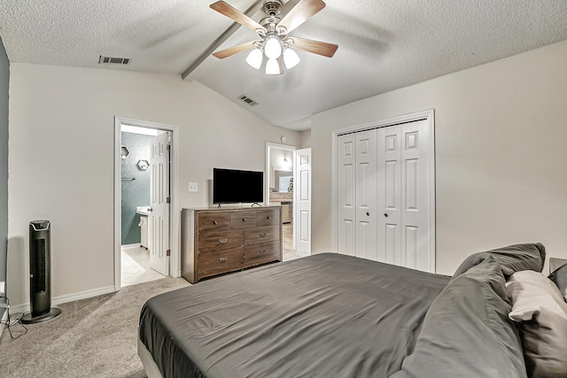 carpeted bedroom featuring connected bathroom, ceiling fan, lofted ceiling with beams, a textured ceiling, and a closet