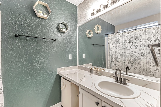 bathroom featuring a shower with curtain, vanity, and a textured ceiling