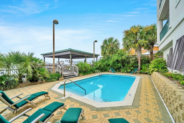 view of swimming pool with a gazebo, a wooden deck, and a patio area