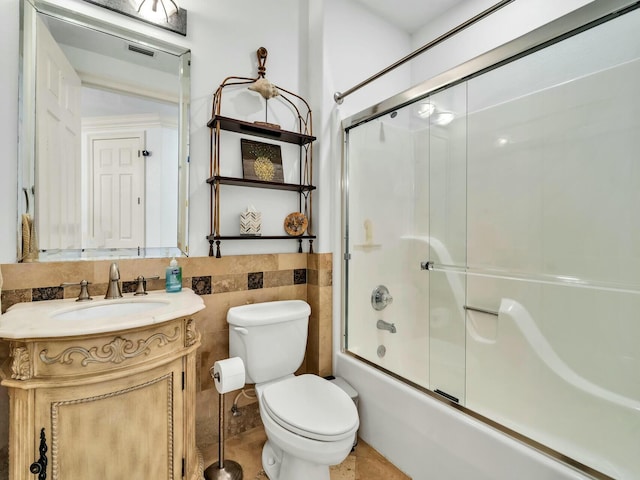 full bathroom featuring vanity, toilet, and combined bath / shower with glass door