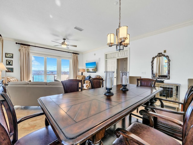 dining room featuring ceiling fan with notable chandelier and crown molding