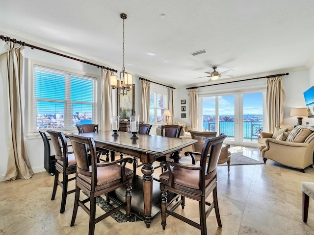 dining room with ceiling fan with notable chandelier and crown molding