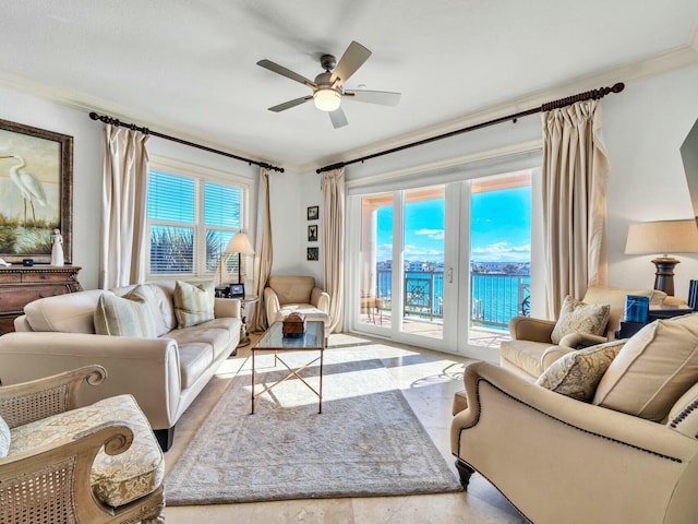 living room featuring ceiling fan, a water view, and ornamental molding