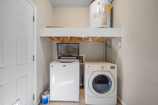 washroom with washer and clothes dryer, electric water heater, and light tile patterned floors