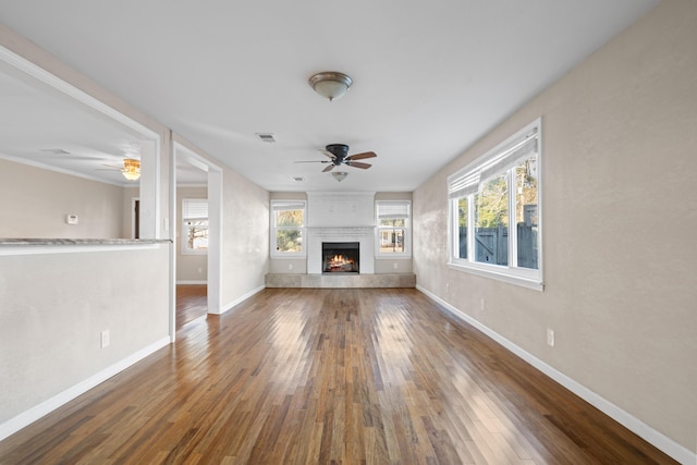 unfurnished living room with ceiling fan, a fireplace, and dark hardwood / wood-style floors