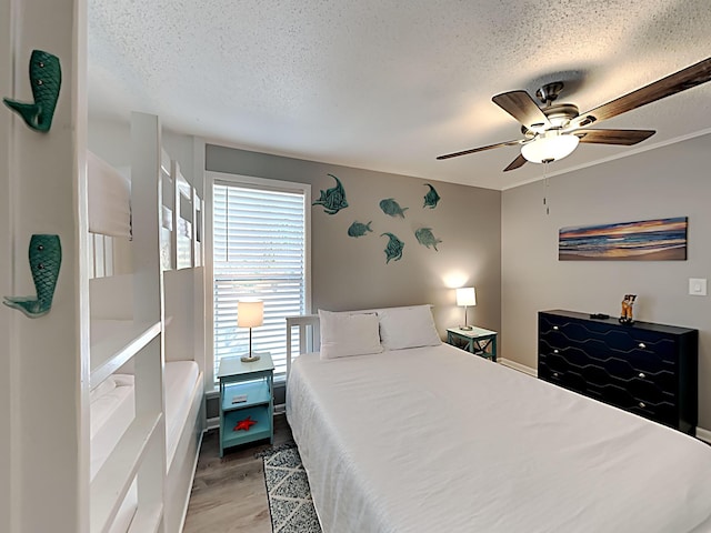 bedroom featuring ceiling fan, light wood-type flooring, and a textured ceiling