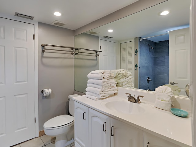 bathroom with toilet, vanity, and tile patterned floors