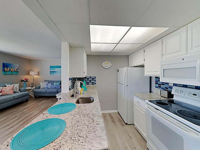 kitchen with sink, white cabinetry, white appliances, tasteful backsplash, and light hardwood / wood-style flooring