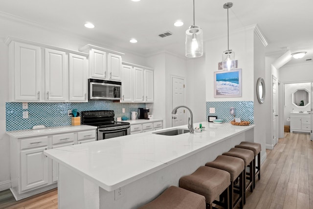 kitchen with white cabinets, light stone counters, sink, decorative light fixtures, and black electric range