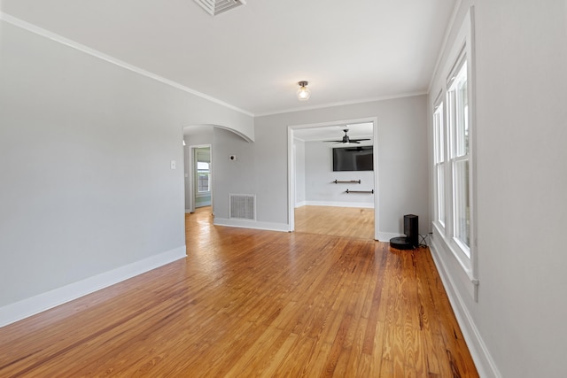 unfurnished living room featuring ceiling fan, light wood-type flooring, and ornamental molding