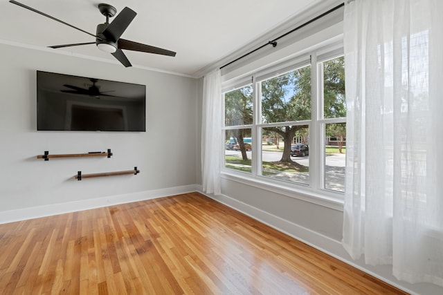 spare room featuring crown molding, a healthy amount of sunlight, and hardwood / wood-style flooring