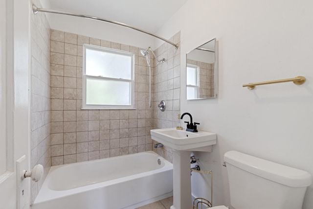 bathroom featuring tile patterned floors, tiled shower / bath, and toilet