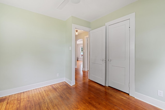 unfurnished bedroom with ceiling fan and hardwood / wood-style flooring